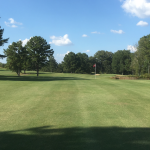 Panoramic view of a lush green golf course at Persimmon Hills Golf Course. Smooth