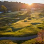 Panoramic view of a lush green golf course at Pete Dye River Course of Virginia Tech. Smooth