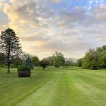 Panoramic view of a lush green golf course at Pine Creek Golf Club. Smooth