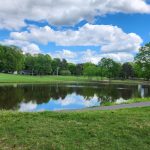 Panoramic view of a lush green golf course at Pine Lake Country Club. Smooth