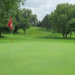 Panoramic view of a lush green golf course at Pine Lake Golf & Tennis. Smooth