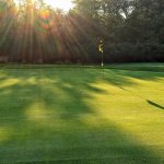 Panoramic view of a lush green golf course at Pine Meadows Golf Club. Smooth