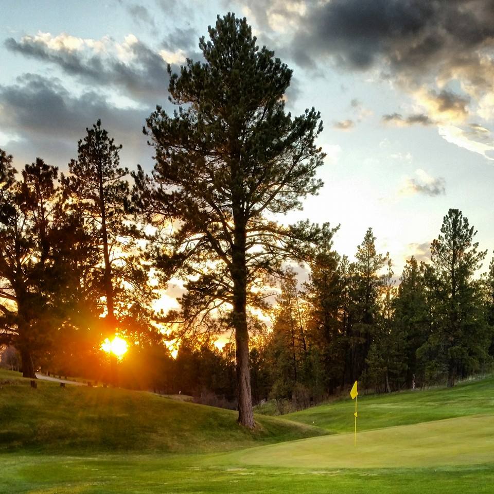 Panoramic view of a lush green golf course at Pine Meadows Golf Course. Smooth