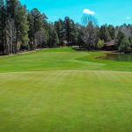 Panoramic view of a lush green golf course at Pinetop Lakes Country Club. Smooth