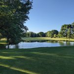 Panoramic view of a lush green golf course at Pleasant Valley Golf Course. Smooth