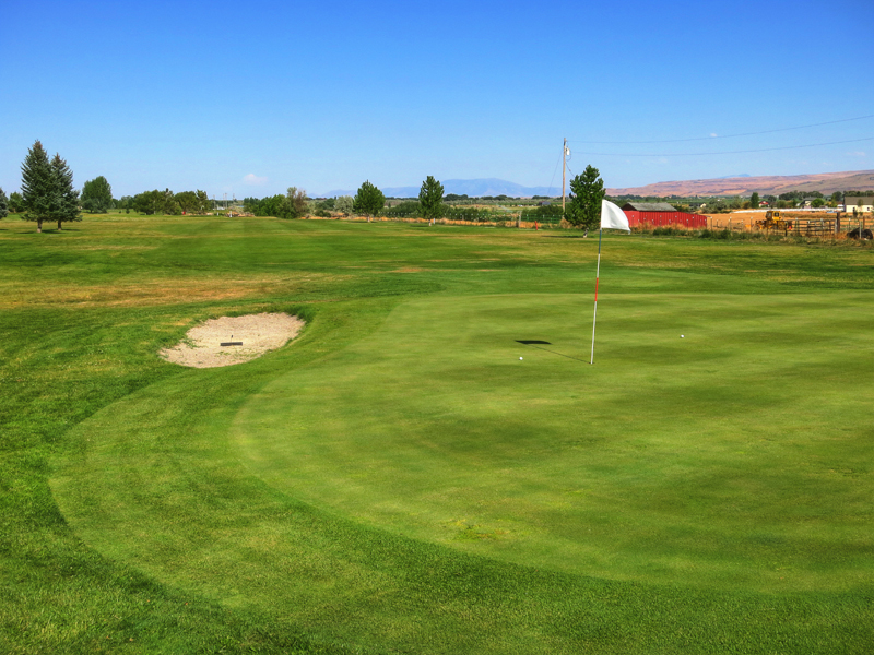 Panoramic view of a lush green golf course at Pleasant Valley Golf Course. Smooth