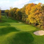 Panoramic view of a lush green golf course at PohlCat Golf Course. Smooth