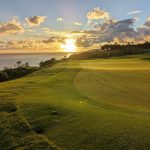 Panoramic view of a lush green golf course at Princeville Makai Golf Club. Smooth