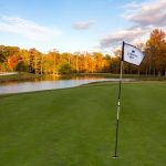 Panoramic view of a lush green golf course at Queenstown Harbor Golf. Smooth