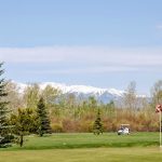 Panoramic view of a lush green golf course at Red Lodge Mountain Golf Course. Smooth