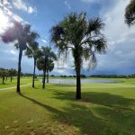 Panoramic view of a lush green golf course at River Greens Golf Course. Smooth