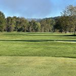 Panoramic view of a lush green golf course at River Greens Golf Course. Smooth