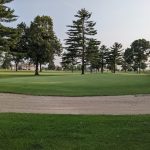 Panoramic view of a lush green golf course at River Ridge Golf Course. Smooth