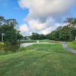 Panoramic view of a lush green golf course at River Run Golf Club & Community. Smooth