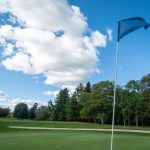 Panoramic view of a lush green golf course at Riverside Golf. Smooth