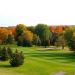 Panoramic view of a lush green golf course at Riverside Golf Course. Smooth