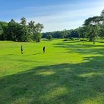 Panoramic view of a lush green golf course at Riverside Golf Course. Smooth