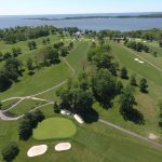 Panoramic view of a lush green golf course at Rocky Point Golf Course. Smooth