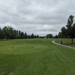 Panoramic view of a lush green golf course at Rose Creek Golf Course. Smooth