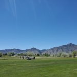 Panoramic view of a lush green golf course at Round Mountain Golf Course. Smooth