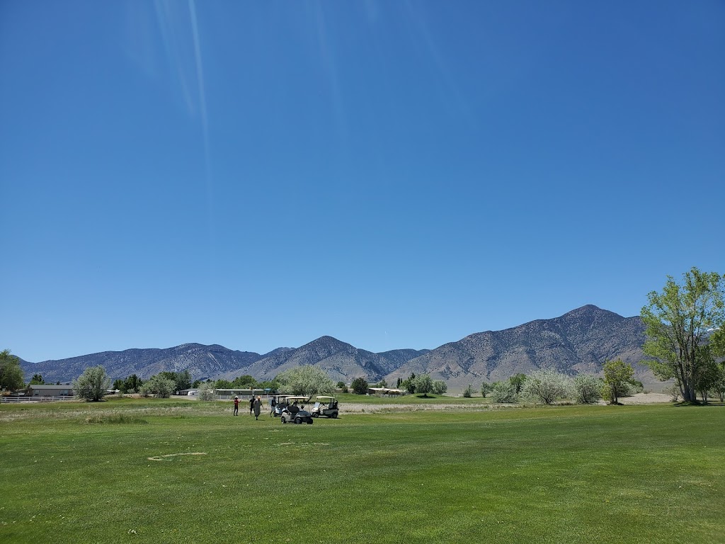 Panoramic view of a lush green golf course at Round Mountain Golf Course. Smooth