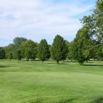 Panoramic view of a lush green golf course at Sakima Country Club. Smooth