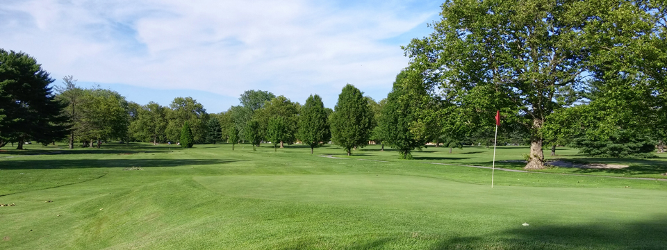 Panoramic view of a lush green golf course at Sakima Country Club. Smooth