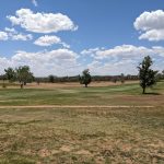 Panoramic view of a lush green golf course at Santa Fe Country Club. Smooth