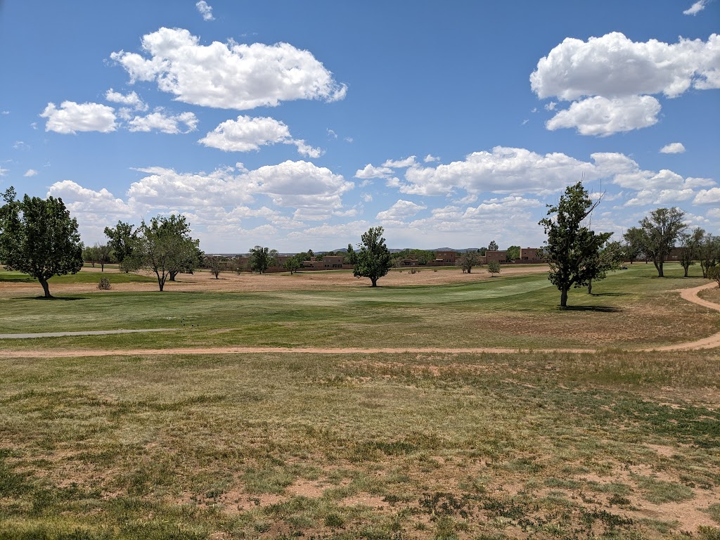 Panoramic view of a lush green golf course at Santa Fe Country Club. Smooth