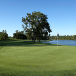 Panoramic view of a lush green golf course at Shoreline Golf Course. Smooth