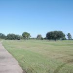 Panoramic view of a lush green golf course at Southern Oaks Country Club. Smooth