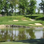 Panoramic view of a lush green golf course at Spirit Hollow Golf Course. Smooth