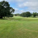 Panoramic view of a lush green golf course at Spring Hill Golf Course. Smooth