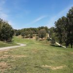 Panoramic view of a lush green golf course at Spring Lake 9 Hole Golf Course. Smooth