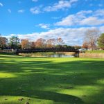 Panoramic view of a lush green golf course at Squirrel Run Country Club. Smooth