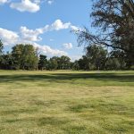 Panoramic view of a lush green golf course at St. Ann Golf Course. Smooth