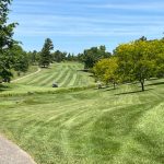 Panoramic view of a lush green golf course at St. Denis Golf Course & Party Center. Smooth