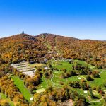 Panoramic view of a lush green golf course at Sugar Mountain Public Golf Course. Smooth