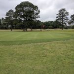 Panoramic view of a lush green golf course at Sugar Oaks Golf Course. Smooth