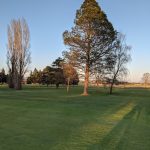 Panoramic view of a lush green golf course at Sunset Grove Golf Course. Smooth