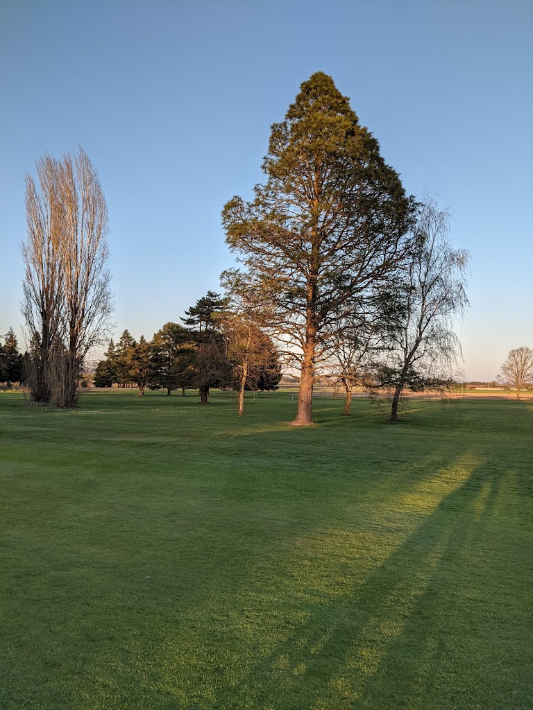 Panoramic view of a lush green golf course at Sunset Grove Golf Course. Smooth