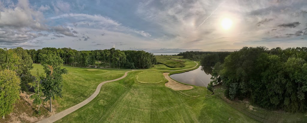 Panoramic view of a lush green golf course at Swan Point Yacht & Country Club. Smooth