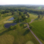 Panoramic view of a lush green golf course at Sweet Water Golf Course. Smooth