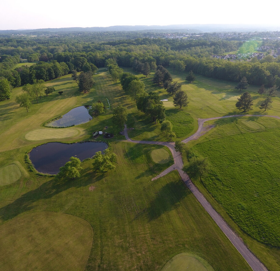 Panoramic view of a lush green golf course at Sweet Water Golf Course. Smooth