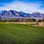 Panoramic view of a lush green golf course at TPC Las Vegas. Smooth