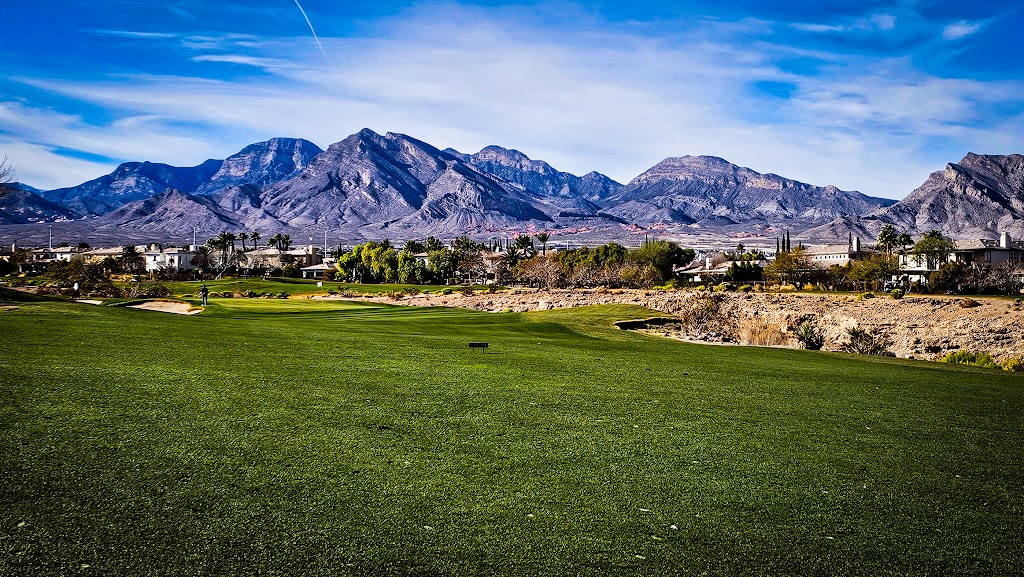 Panoramic view of a lush green golf course at TPC Las Vegas. Smooth