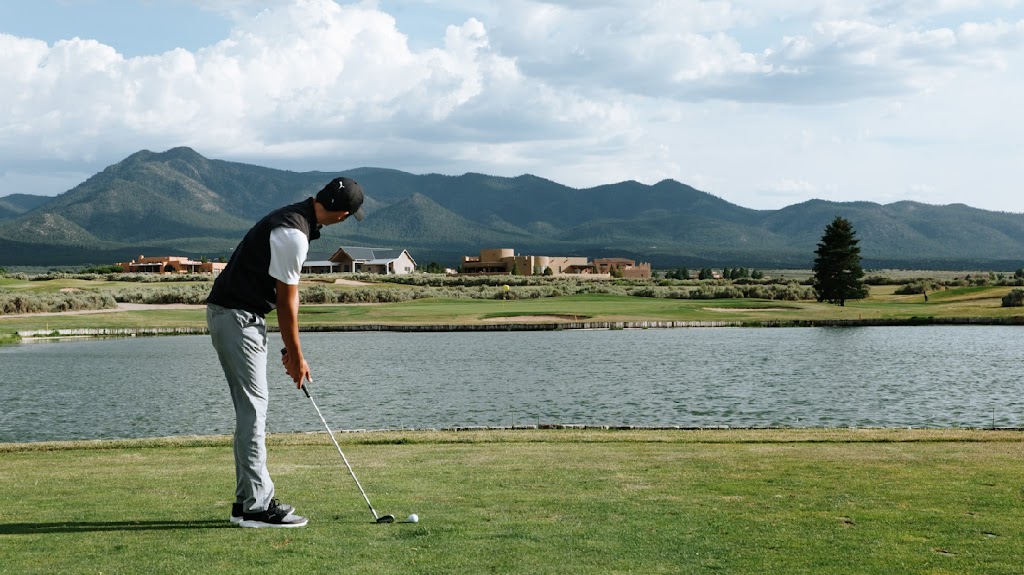 Panoramic view of a lush green golf course at Taos Country Club. Smooth