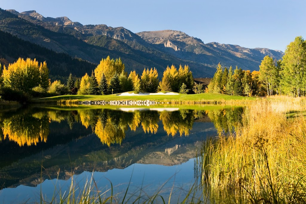 Panoramic view of a lush green golf course at Teton Pines. Smooth