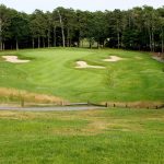 Panoramic view of a lush green golf course at The Captains Golf Course. Smooth