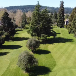 Panoramic view of a lush green golf course at The Children's Course. Smooth